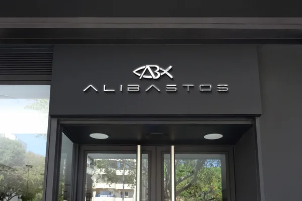 Fachada de loja preta exibindo o letreiro cromado Alibastos, ilustrando o serviço de criação de logo para lojas e varejo.