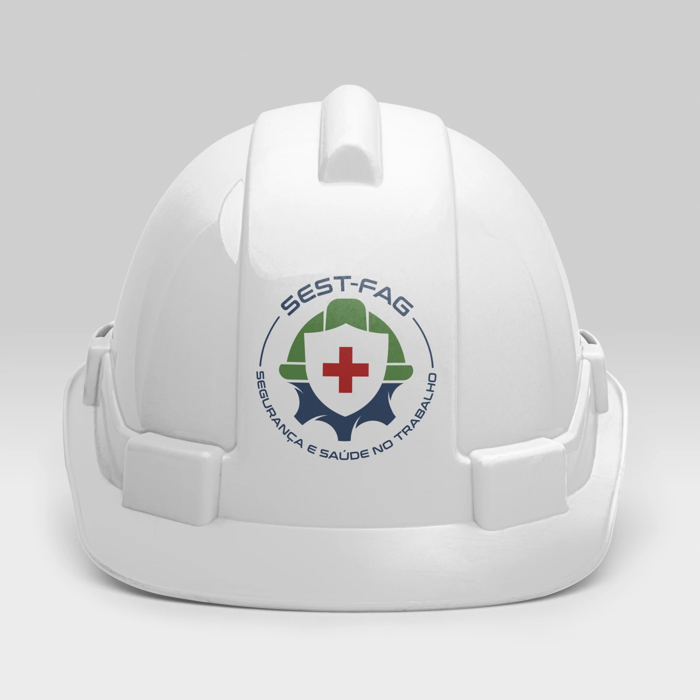 Logotipo estratégico da empresa SEST-FAG focado em segurança e saúde no trabalho, apresentando capacete verde, escudo e cruz vermelha.